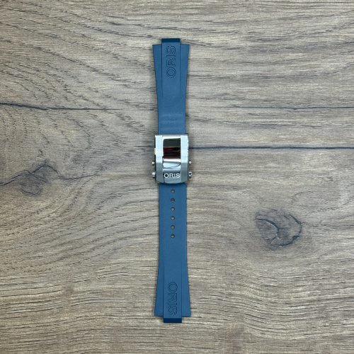 Ремешок для часов Oris из каучука, синий, со стальной клипсой Каучуковые ремешки идеально подходят для активного образа жизни. Они легче и теплее металлических браслетов, а ощущаются на руке как вторая кожа. Большое преимущество каучука в том, что он не боится воды. У нас присутствуют только высококачественные материалы и оригинальный товар от производителя.